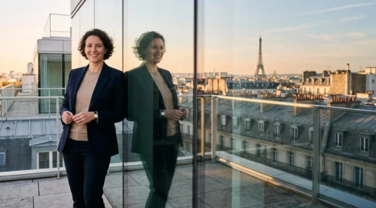 Entrepreneur francais confiant observant les toits de Paris depuis une terrasse vitree, symbolisant la construction d'une image de marque digitale de confiance
