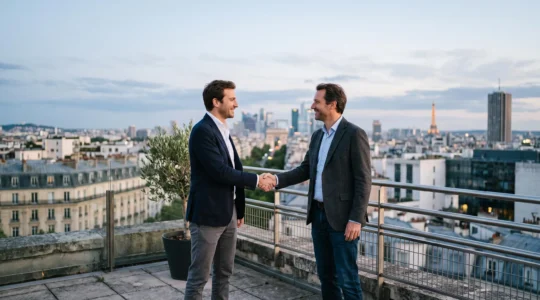 Deux professionnels se serrant la main devant un immeuble parisien en verre, symbolisant un partenariat stratégique gagnant-gagnant